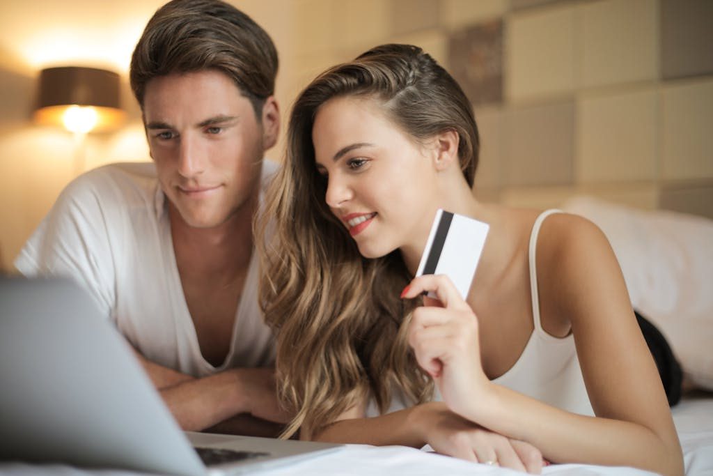 Cheerful couple making online purchases at home